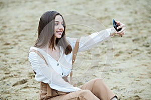 Girl outdoors texting on her mobile phone. Girl with phone. Portrait of a happy woman text sms message on her phone.