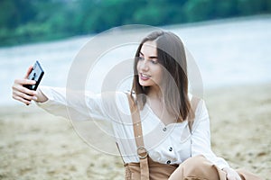 Girl outdoors texting on her mobile phone. Girl with phone. Portrait of a happy woman text sms message on her phone.