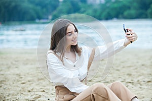 Girl outdoors texting on her mobile phone. Girl with phone. Portrait of a happy woman text sms message on her phone.