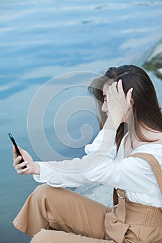 Girl outdoors texting on her mobile phone. Girl with phone. Portrait of a happy woman text sms message on her phone.