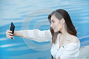 Girl outdoors texting on her mobile phone. Girl with phone. Portrait of a happy woman text sms message on her phone.