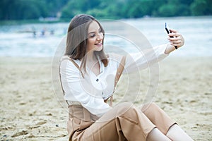 Girl outdoors texting on her mobile phone. Girl with phone. Portrait of a happy woman text sms message on her phone.