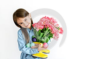 Girl with painted Easter eggs and a bouquet of tulips in her hands