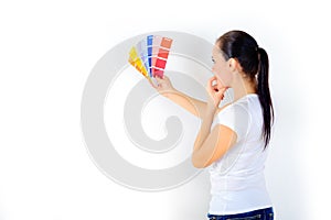 Girl painter chooses the color of paint to repair