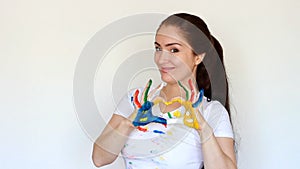 Girl painter student smiles and shows the heart. Love of art and profession. Dirty clothes and dirty hands of the artist