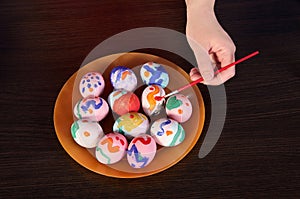 Girl paints Easter eggs. hand, brush and paint on the table. preparation for Easter