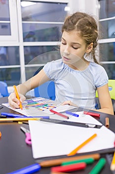 Girl paints a felt pen drawing of photo