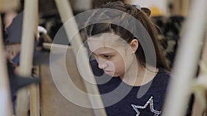 The girl paints a picture in the children`s studio of fine art .. Many easels and canvases on the table.