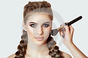 The Girl paints powder on the face, completes the smokey eyes make-up in the beauty salon. Professional skin care