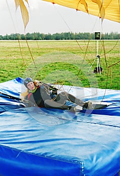 The girl-parachutist lands on a floor-mat