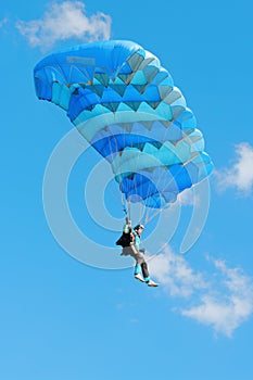 The girl-parachutist under a blue parachute photo