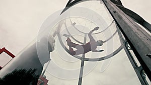 Girl paratrooper performing a parachute jumping in a wind tunnel