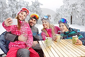 Girl with parents and brother making selfie at winter holiday