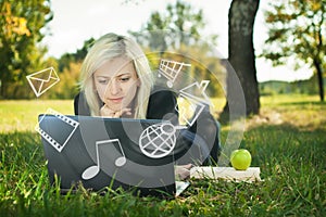 Girl in park with laptop multimedia concept