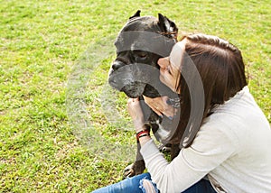 Girl in the park walking with their big dog Cane Corso