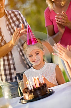 Girl with party hat and birthday cake