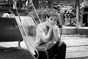 Girl pauper sitting alone at playground photo