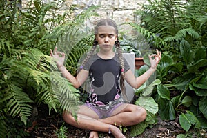Girl in peaceful meditation amidst verdant foliage