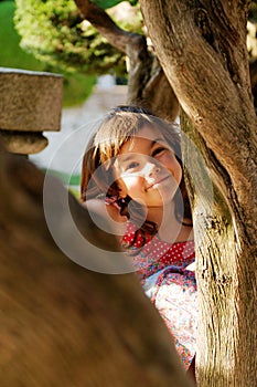 Girl Peeking Around Tree