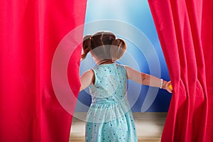Girl Peeking Through A Stage Curtain