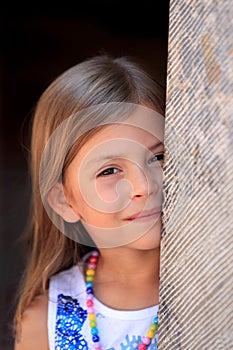 Girl peeping from behind pillar