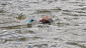 Girl peeping from lake surface at summer nature closeup.