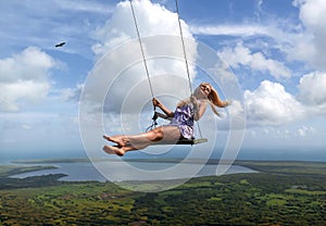 Girl with perfect legs and flying hair swinging on the Redonda mountain of Dominican Republic