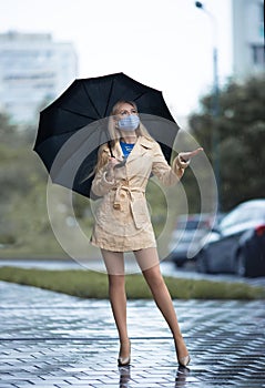 Girl with perfect legs in pantyhose with umbrella under the rain