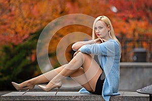 Girl with perfect legs posing in the autumn park.