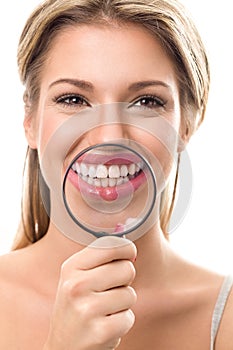 Girl with perfect teeth behind magnifying glass