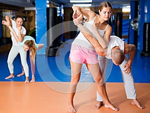 Girl performing elbow strike and wristlock to male opponent during self defence training