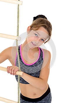 Girl performing gymnastic exercise on rope ladder.