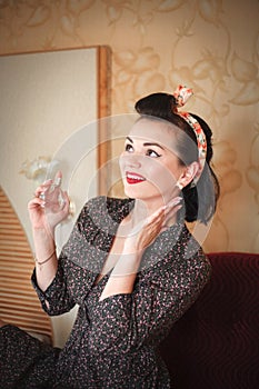 Girl with perfume. Closeup beautiful young woman pretty smiling pinup girl holding bottle of perfume and smelling aroma.