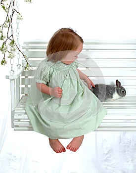 Girl Petting Bunny on Swing