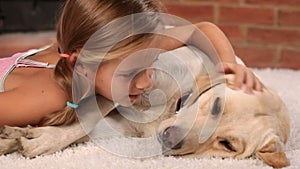 Girl petting her labrador dog - closeup