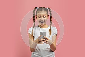 Girl with phone expressing amazement on pink