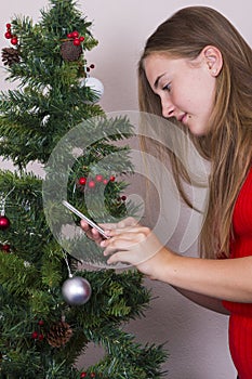 Girl with phone near New Year tree