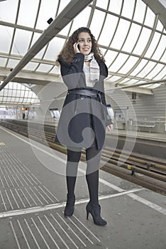 Girl phoning in train station photo
