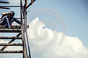 Girl the photographer sits an old ladder