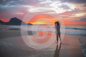 girl photographer at sunrise on Copacabana beach. Rio