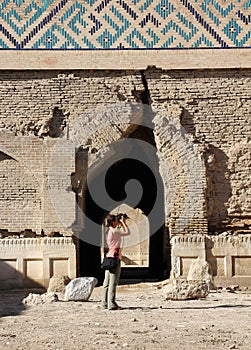 Girl photographer take a picture in arch of the ruined temple