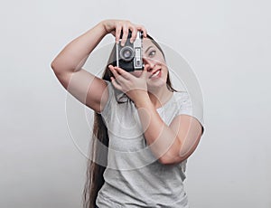 Girl photographer takes a photo with an old film camera