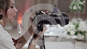 Girl photographer takes pictures in a restaurant, banquet hall at wedding event.