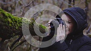 Girl photographer walks through the autumn forest and takes pictures of nature. cinematic shot. slow motion