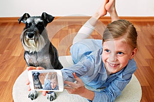 Girl photographing herself and her dog