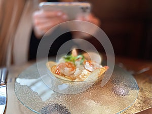 Girl photographs a restaurant dish on a smartphone