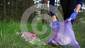 Girl pick up trash doing plogging.Plogging concept. Collecting the litter in garbage bag. Environment plastic pollution
