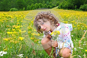Girl picking flowers in yellow spring meadow