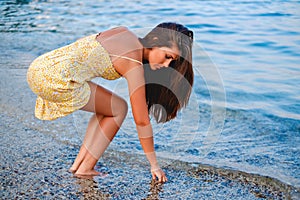 Girl picking up seashells on the beach