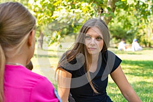 The girl on a picnic listens attentively to the interlocutor photo